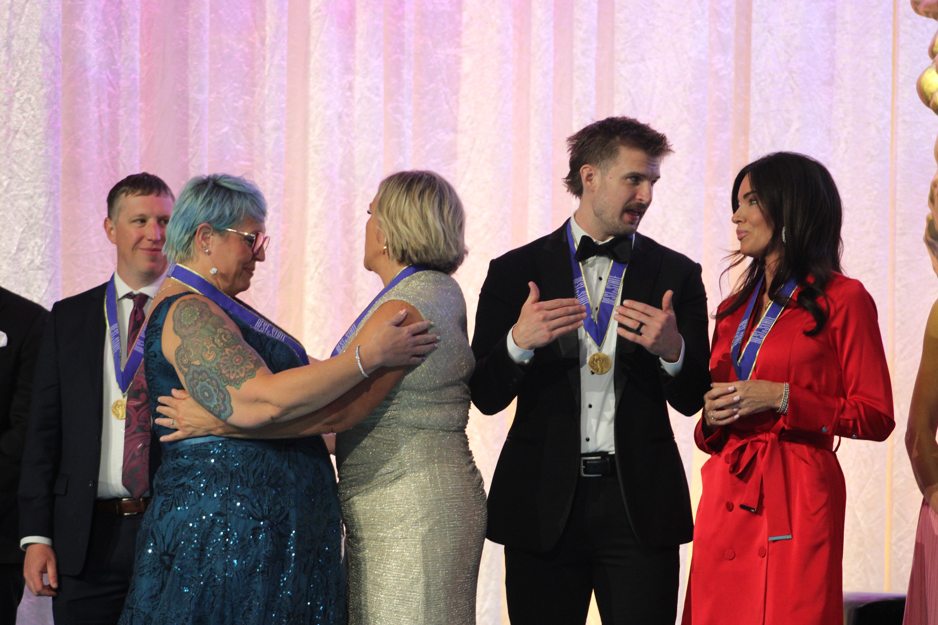2026 BOSS® medalists share a moment on stage after the awards presentation.