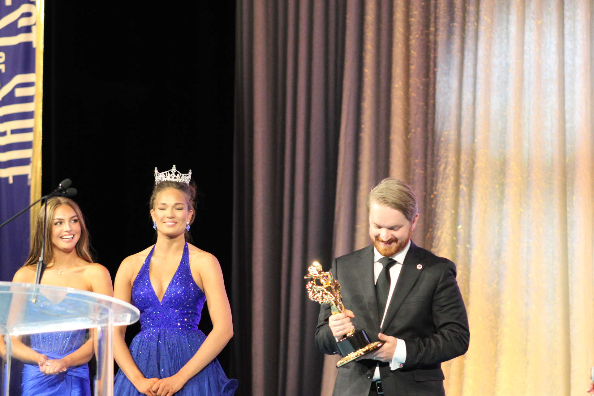 A 2026 honoree receives the BOSS® statue with Miss Utah royalty looking on.